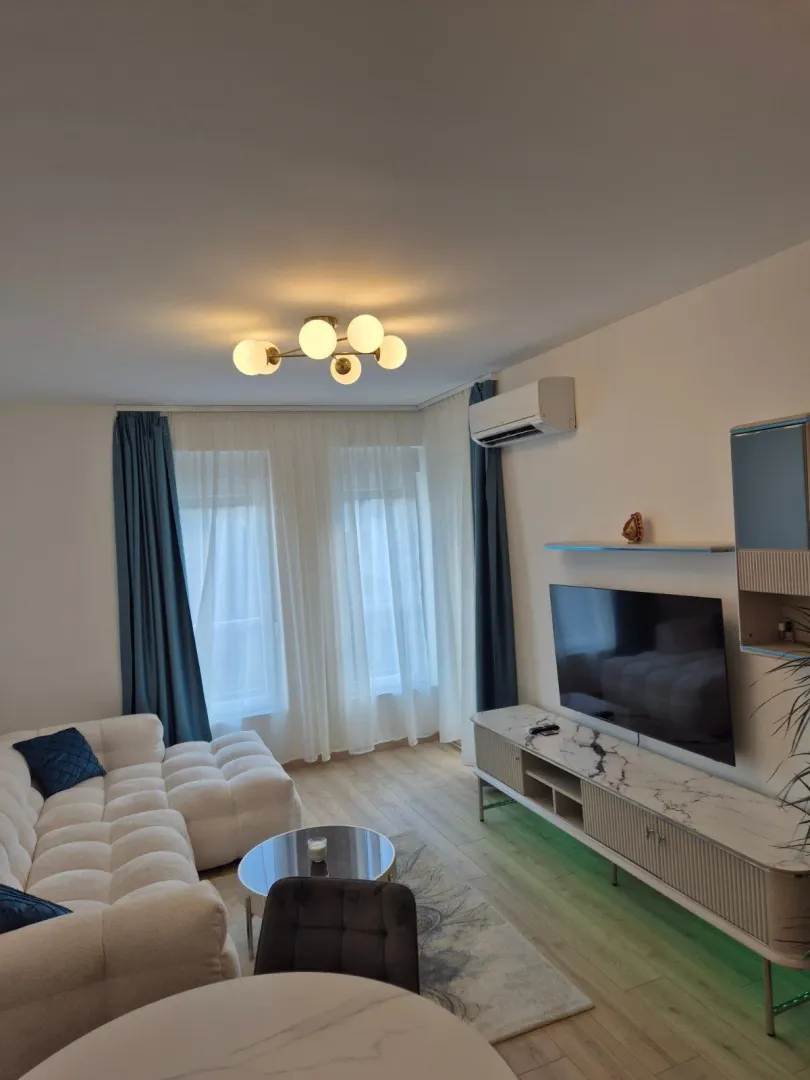 Living room with a sectional sofa, TV, and dining table.