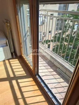 Pogled kroz balkonska vrata na manji spoljni balkon sa metalnom ogradom. - image 15