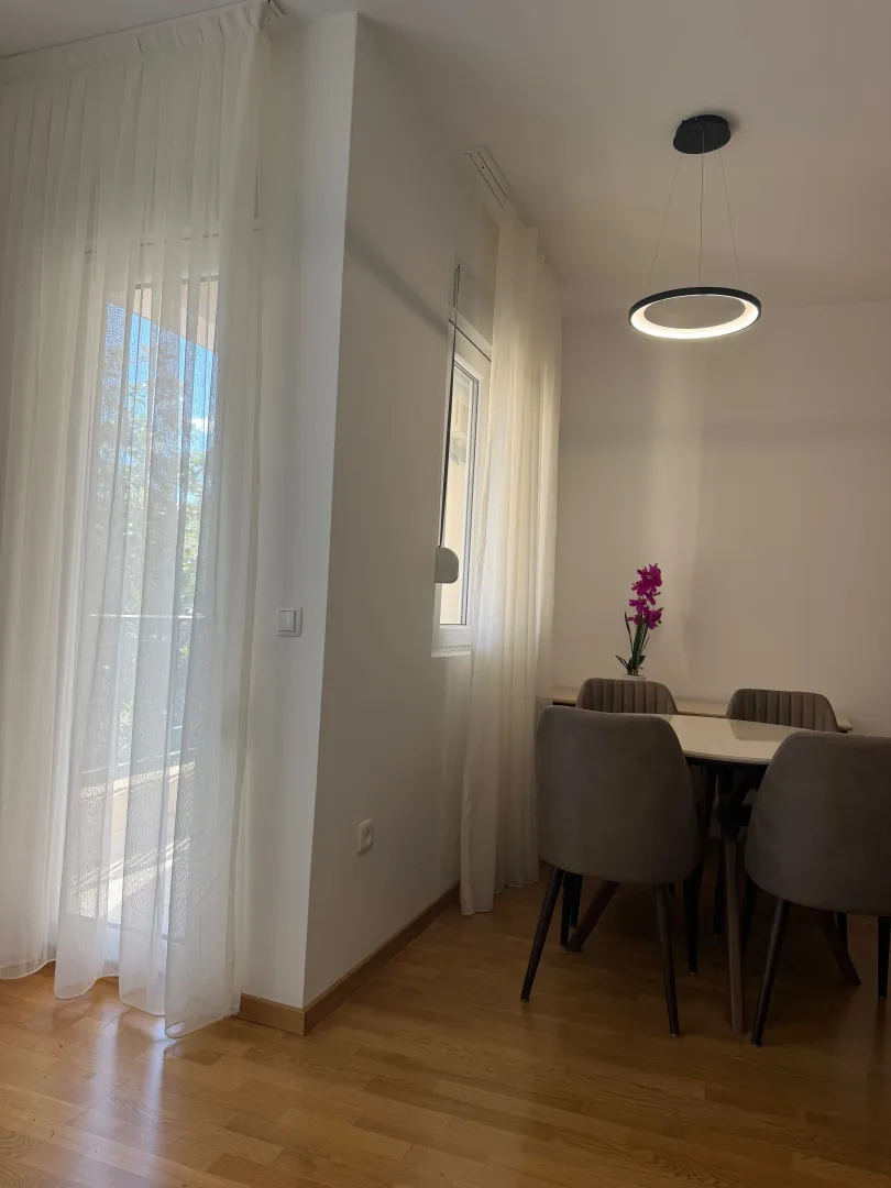 Svijetao dnevni boravak sa trpezarijom i izlazom na terasu.