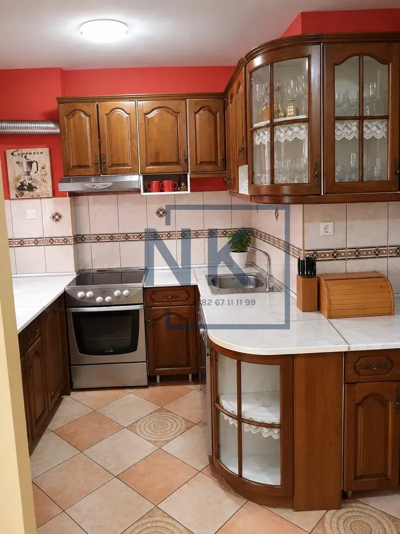 Traditional kitchen with wooden cabinetry, stove, and sink.