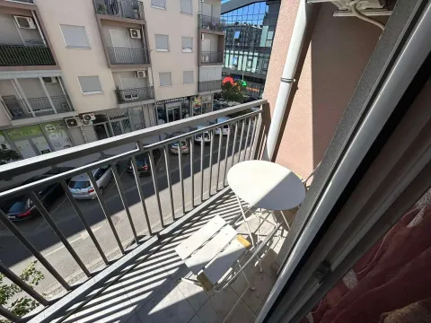 Manji namješteni balkon sa stolom i stolicama i pogledom na ulicu. - image 3