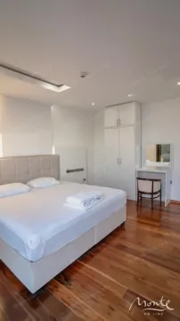 Bedroom with a double bed, a white wardrobe, and a vanity desk with a mirror. - image 14