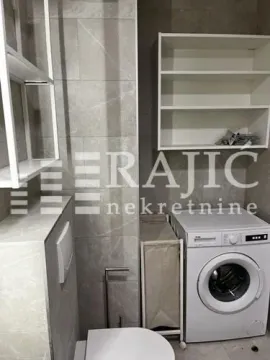 Modern bathroom with washing machine and white shelves. - image 2