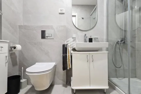Modern bathroom equipped with a walk-in shower, washbasin, and mirror. - image 11