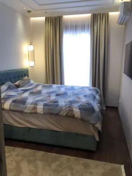 Bright bedroom with a double bed and curtains. - image 16