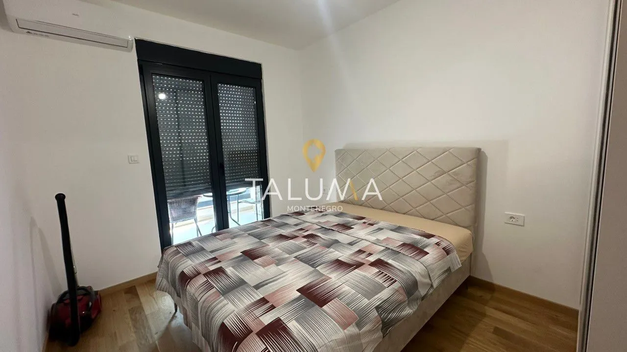 Furnished bedroom with a double bed and balcony access.