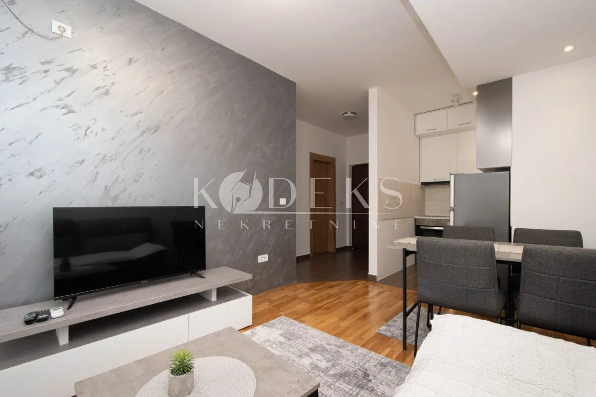 Living room with a television and an adjoining dining area.