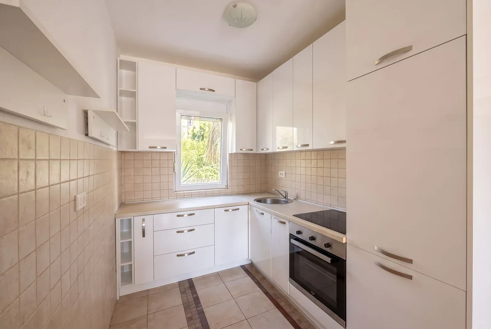 Smaller white kitchen with a built-in oven and hob.