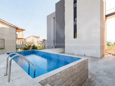 Exterior area of the building with a swimming pool and paved courtyard. - image 12