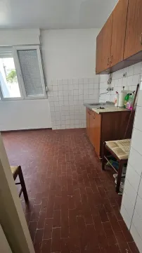Manja kuhinja sa drvenim elementima i pločicama na podu. - image 5