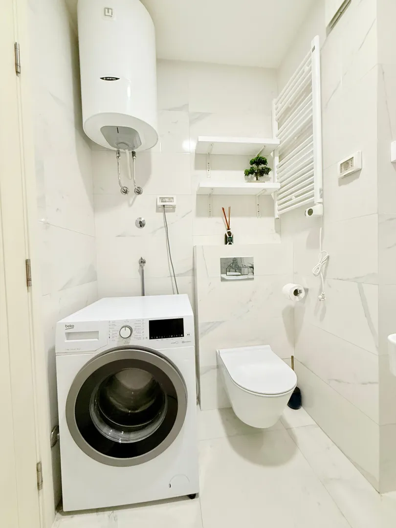 Modern bathroom with a washing machine and sanitary fixtures.