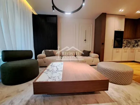 Living room with seating furniture, coffee table, and view of the kitchen. - image 2
