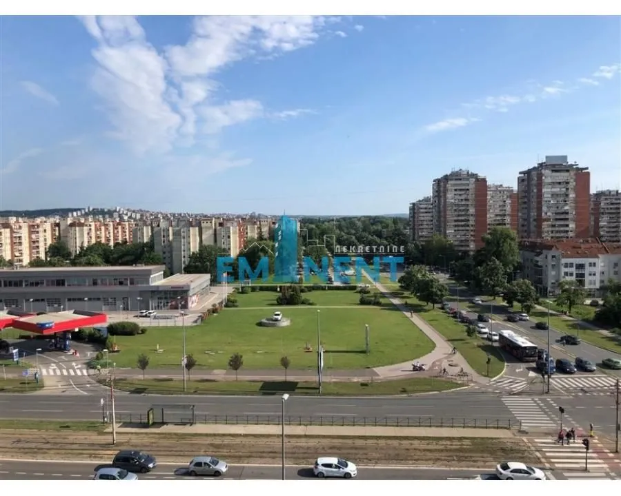 View from the window of surrounding buildings, street, and greenery.