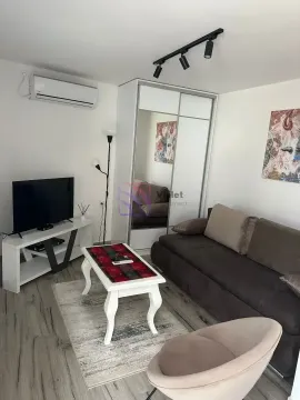 Living room with a sofa, armchair, TV, and white wardrobe. - image 2