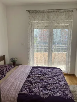 Spavaća soba sa namještenim krevetom pored prozora. - image 11