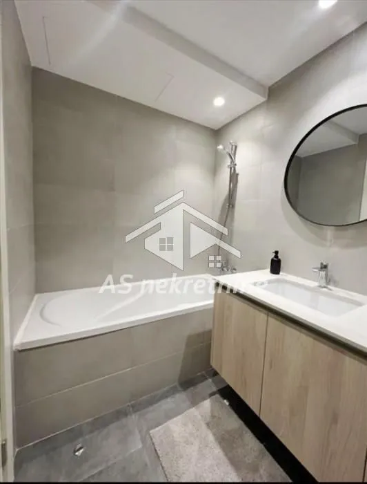 Modernly equipped bathroom with a bathtub and a washbasin.