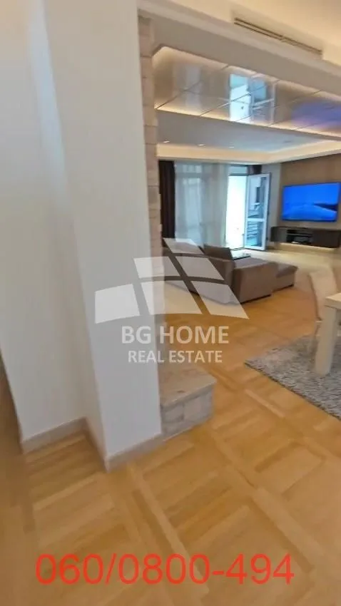 View from the hallway into the spacious living room with a sofa and TV.