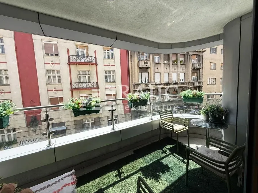 Furnished balcony with seating set and city view.