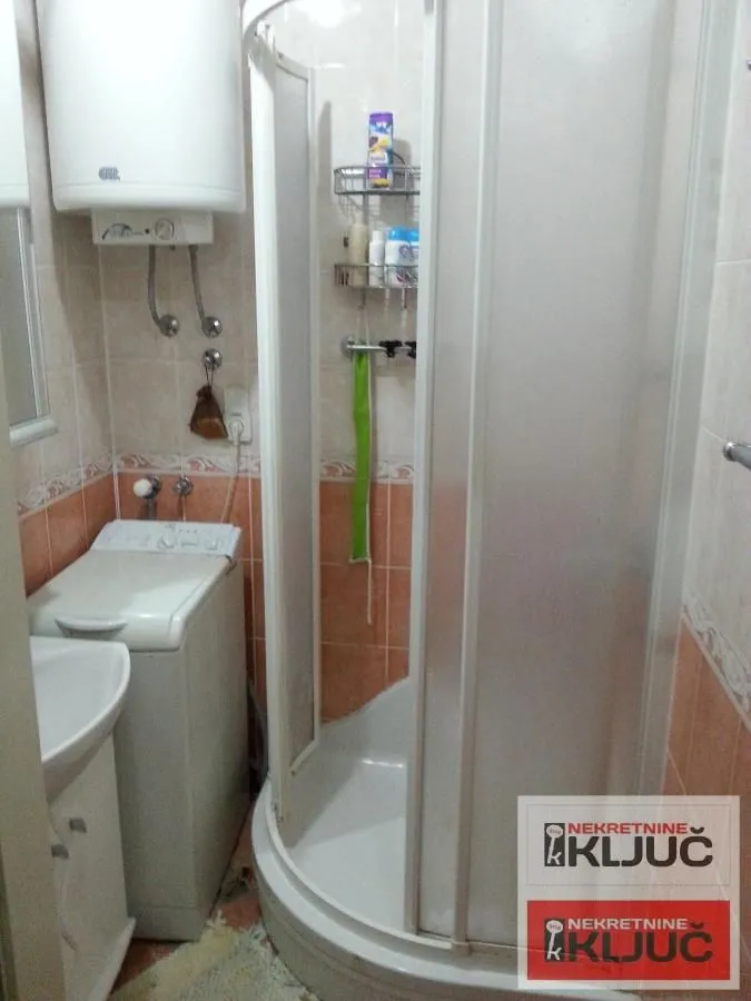 Kupatilo sa tuš kabinom, umivaonikom i bojlerom.