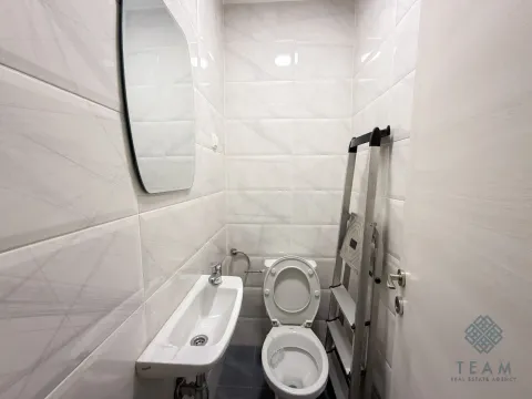 Manje kupatilo sa bijelim pločicama, umivaonikom, WC šoljom i ogledalom. - image 2