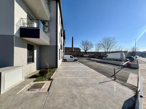 Exterior of the residential building with parking spaces. - image 7