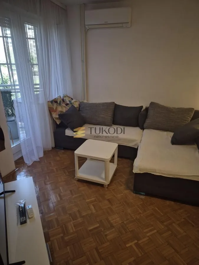 Dnevna soba sa garniturom i izlazom na terasu.