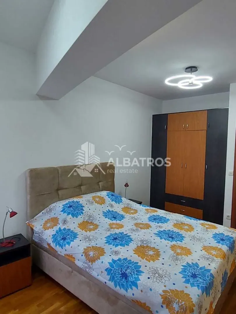 Furnished bedroom with a double bed and a wardrobe.