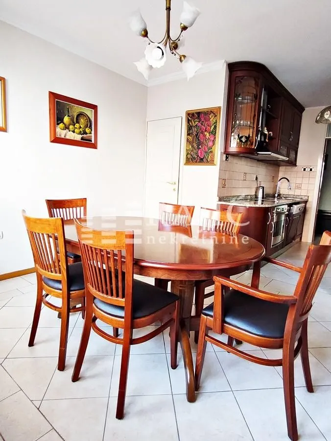 Dining area with a wooden table and chairs, connected to the kitchen.