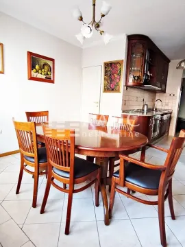 Dining area with a wooden table and chairs, connected to the kitchen. - image 5