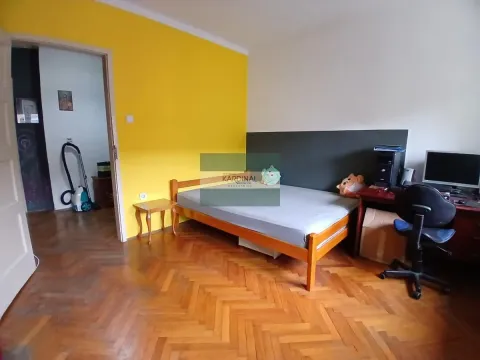 Spavaća soba sa krevetom, radnim stolom i parketom na podu. - image 2