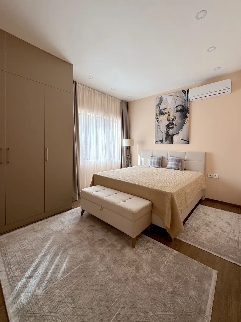 Spacious bedroom with a double bed, large wardrobe and wall art.