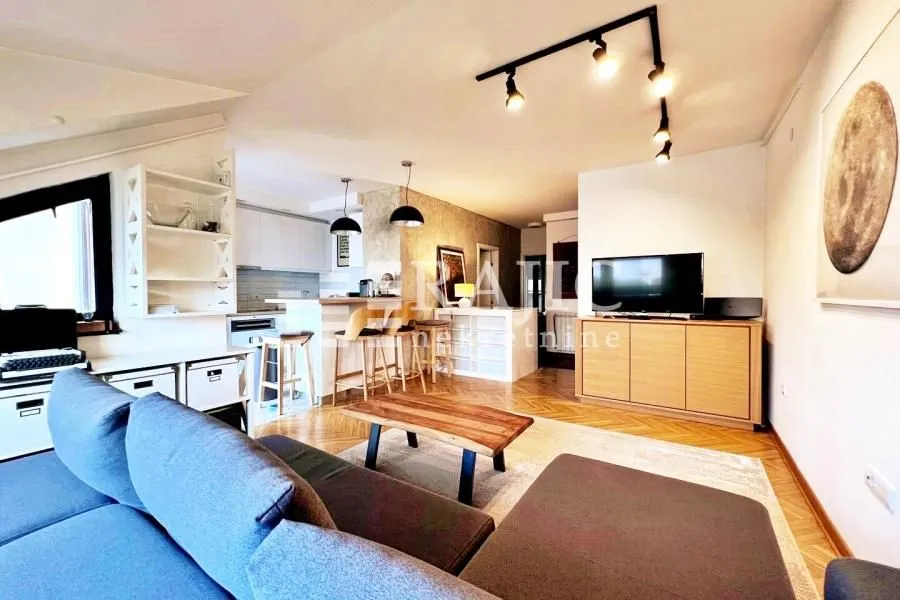 Living room with a sofa and a view towards the kitchen and dining area.