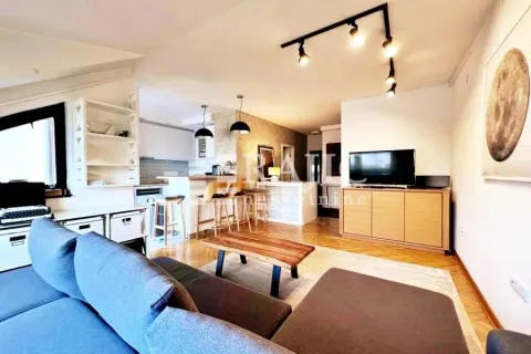 Living room with a sofa and a view towards the kitchen and dining area. - image 2