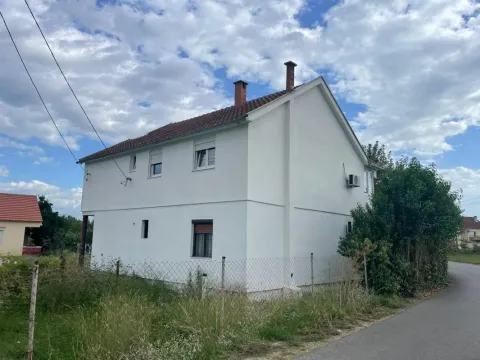 View of the rear side of the house with a white facade and a fenced yard. - image 6