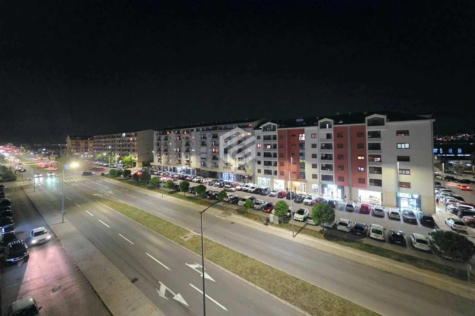 Night view from the window of the illuminated street and buildings.