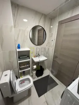 Modernly equipped bathroom with a toilet, washbasin, and shower cabin. - image 4