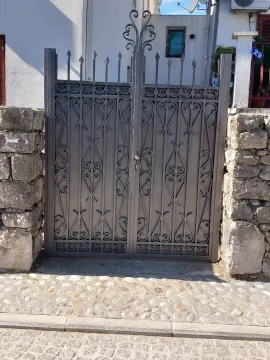 Metalna kapija sa kamenim stubovima na ulazu u dvorište. - image 7