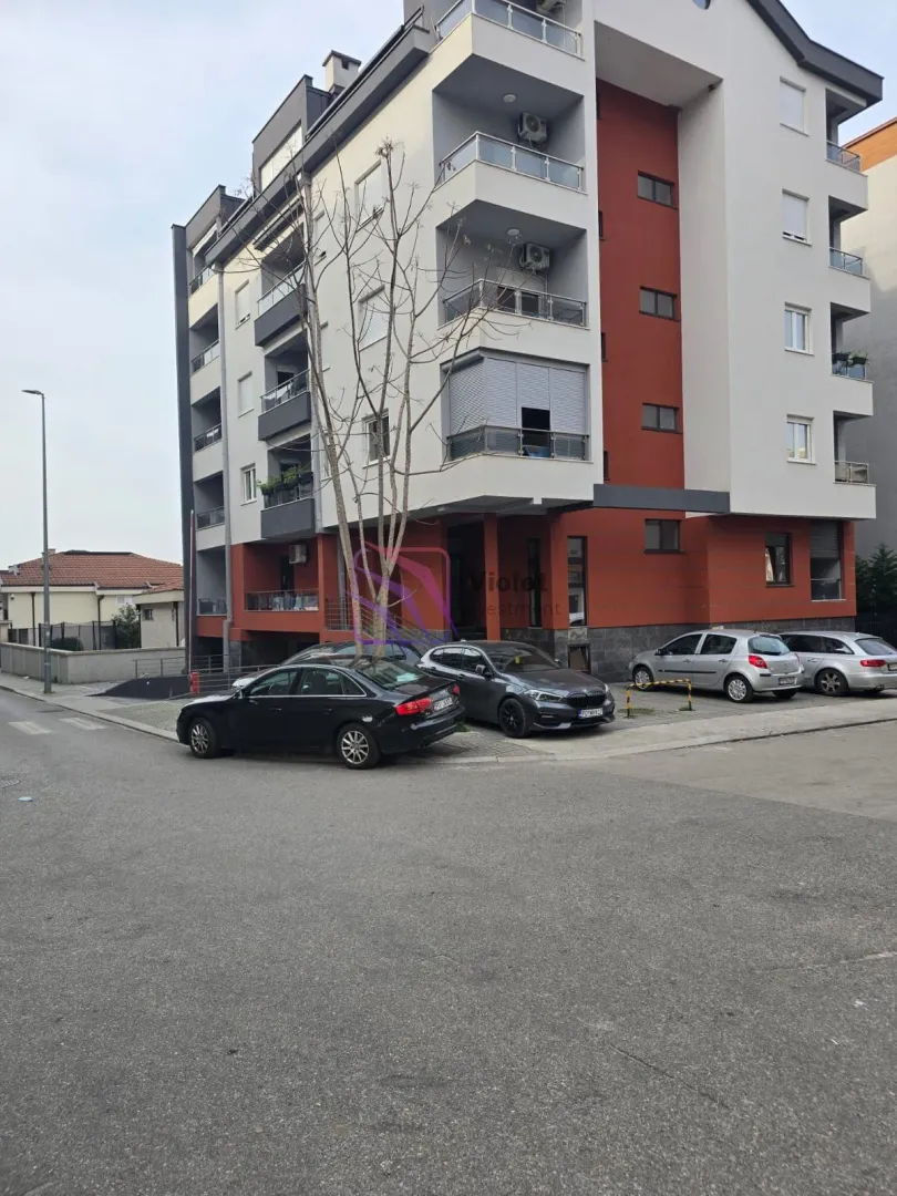 View of the exterior of the residential building and parking in front of the entrance.