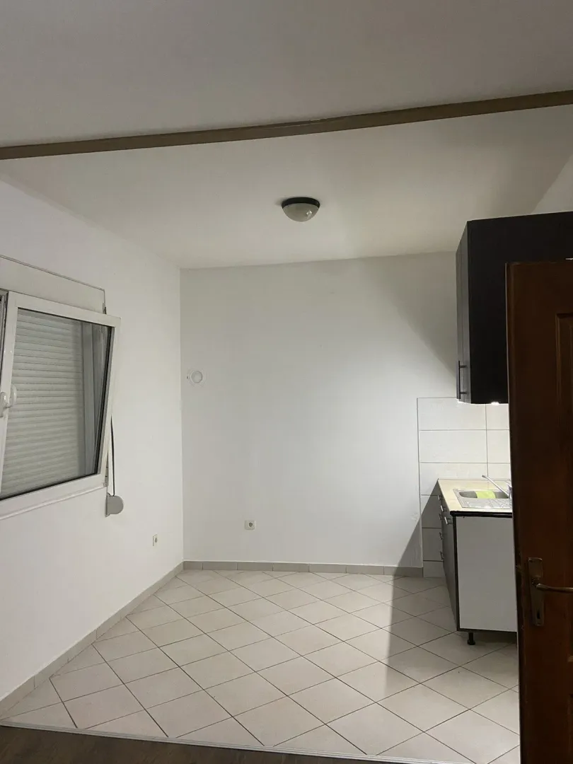 Mala, prazna kuhinja sa pločicama.
