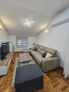 Dnevna soba sa ugaonom garniturom, TV-om i drvenim podom. - image 2