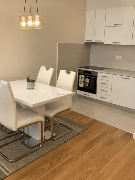 Modern kitchen with dining area and white cabinets. - image 3