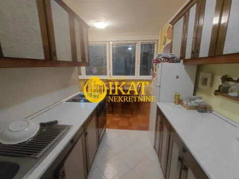 Small kitchen with white countertops and wooden cabinets. - image 9