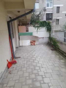 Popločani spoljni prostor sa ogradom i zidom zgrade. - image 16