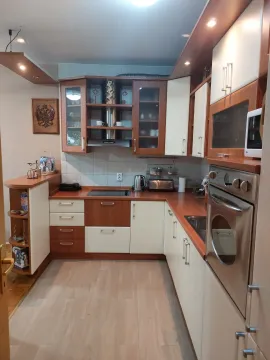 Functional kitchen with wooden and white cabinets. - image 5
