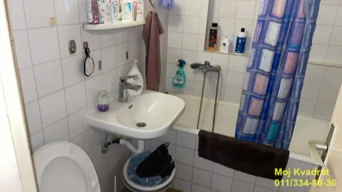 Kupatilo opremljeno umivaonikom, kadom, toaletom i belim zidnim pločicama. - image 7