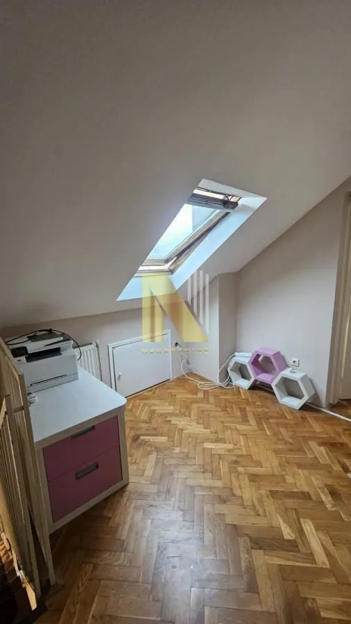 Potkrovlje sa parketom, radnim stolom i krovnim prozorom.