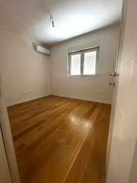 Empty room with wooden flooring, air conditioning unit, and a window. - image 13