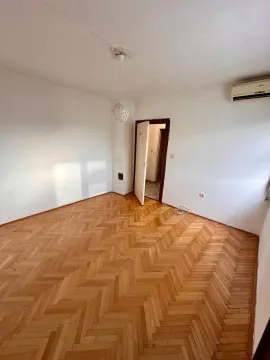 Prazna soba sa parketom i otvorenim vratima. - image 2