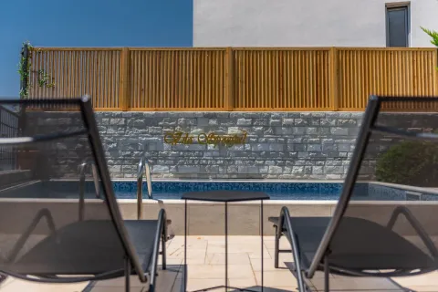 Swimming pool with sun loungers and a wooden fence in the yard. - image 6