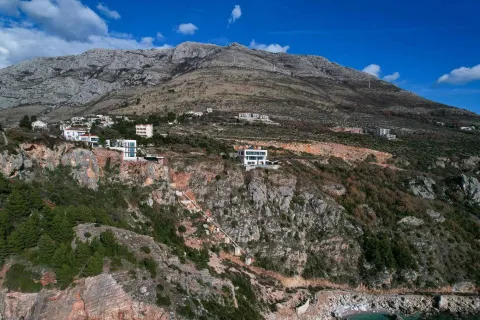 Pogled iz vazduha na kuće smještene na strmoj obali iznad mora. - image 17